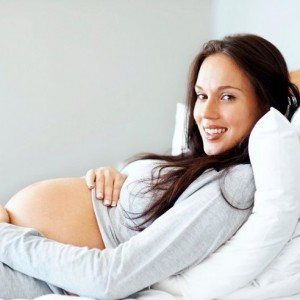 Young pregnant lady lying comfortably on the bed