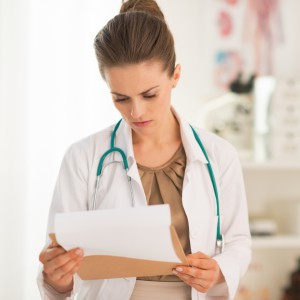Medical doctor woman looking in clipboard