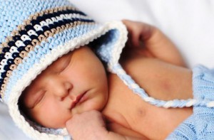новорожденный в вязаной шапочке